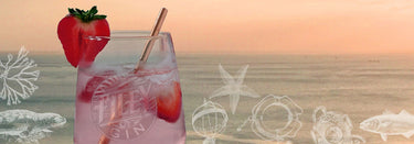 Glass of Filey Gin's Coastal Pink Gin with Strawberry Garnish